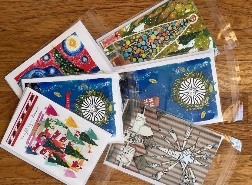 Holiday cards displayed on a wood table — available for purchase